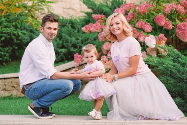 Mutlu genç anne parkta bebeklerini açık ile gülümseyen