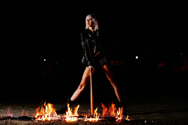 Retrato de jovem loira elegante grunge com o clube perto do fogo — Fotografia de Stock