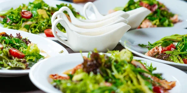 Ensaladas frescas en los platos y una pausa en la mesa —  Fotos de Stock