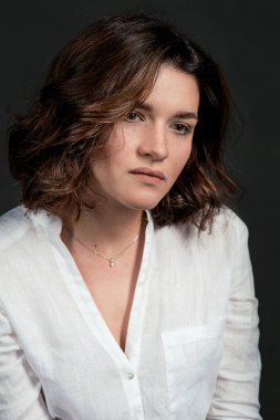 Genç, güzel bir üzgün kadın oyuncu kısa kumral beyaz gömlek ve Mavi pantolon stüdyo ile Portraite