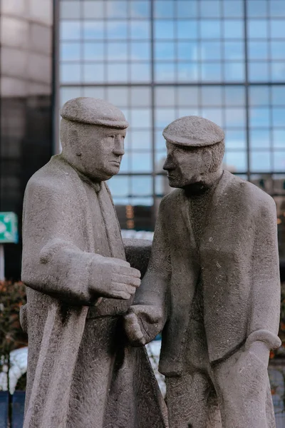 Escultura Piedra Dos Hombres Estrechando Mano Fondo Del Edificio Moderno —  Fotos de Stock