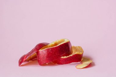 Geri dönüşüm sembolü olarak pembe arka plan üzerinde kırmızı elma kabuğu dolaşımda Ekonomi