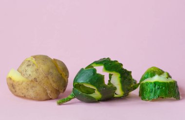 salatalık ve patates kabuğu geri dönüşüm sembolü olarak pembe arka plan üzerinde ekonomi dolaşımda