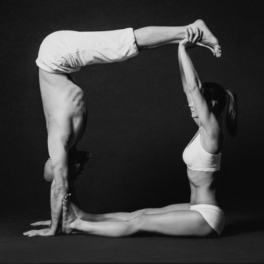 Tek renkli güzel sportif çift portresi: kadın ve erkek birlikte yoga asanas yaptığı Beyaz giysili kapalı 