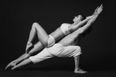 Tek renkli güzel sportif çift portresi: kadın ve erkek birlikte yoga asanas yaptığı Beyaz giysili kapalı 