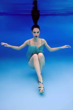 mavi elbise ve topuklu ayakkabılar sualtı yüzme havuzunda güzel ince şık esmer portresi