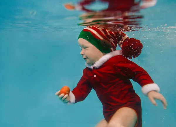 新的一年里在水下出生的白人婴儿和游泳池里的圣诞节套装 — 图库照片