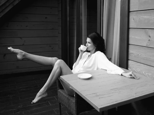 美丽快乐的黑发女人 穿着白色丝绸长袍 在阳台喝咖啡 — 图库照片