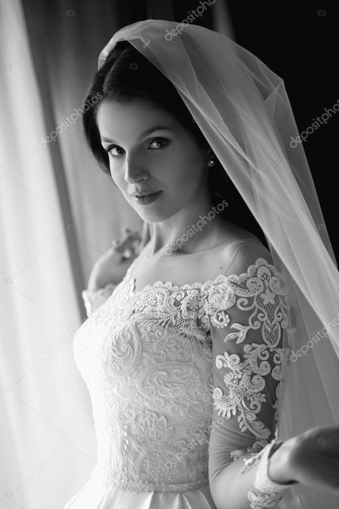 monochrome portrait of caucasian beautiful attractive woman bride in traditional european white dress 