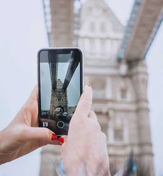 อของผ แดงพร อมสมาร ทโฟนถ ายภาพบนสะพานทาวเวอร ลอนดอนย ไนเต งทอม แนวค ดการเด — ภาพถ่ายสต็อก