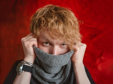 Şalından korkan, panik atak geçiren, koronavirüs ve salgından korkan kızıl saçlı bir adamın portresi. Sağlık, moda, korku, panik konsepti