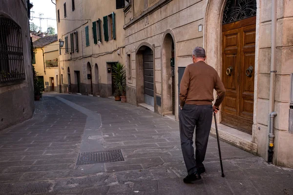 ASCIANO, TUSCANÍA, Italia - hombre desconocido camina por las calles de la ciudad —  Fotos de Stock