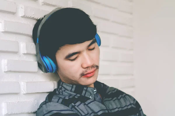 Hipster młody gej słuchania muzyki słuchawki. — Zdjęcie stockowe