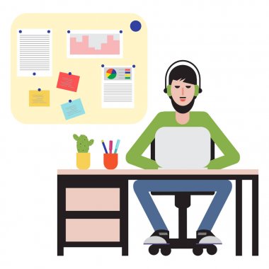 Masada oturan ve dizüstü bilgisayarda çalışan adam.