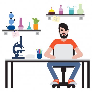 Masada oturan ve dizüstü bilgisayarda çalışan adam.