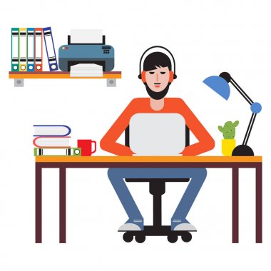 Masada oturan ve dizüstü bilgisayarda çalışan adam.