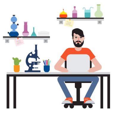 Masada oturan ve dizüstü bilgisayarda çalışan adam.