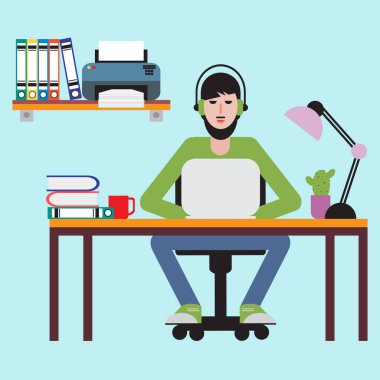 Masada oturan ve dizüstü bilgisayarda çalışan adam.