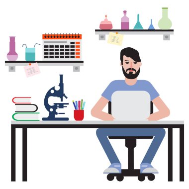 Masada oturan ve dizüstü bilgisayarda çalışan adam.