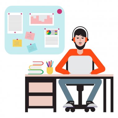 Masada oturan ve dizüstü bilgisayarda çalışan adam.