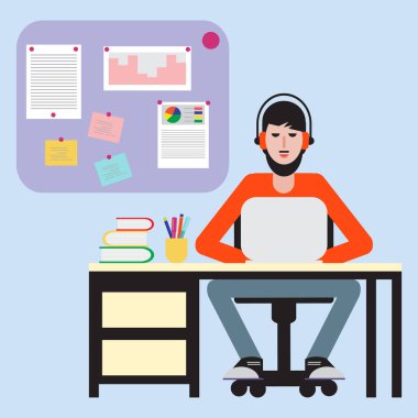 Masada oturan ve dizüstü bilgisayarda çalışan adam.