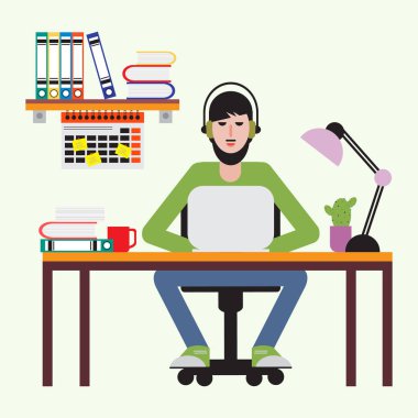 Masada oturan ve dizüstü bilgisayarda çalışan adam.