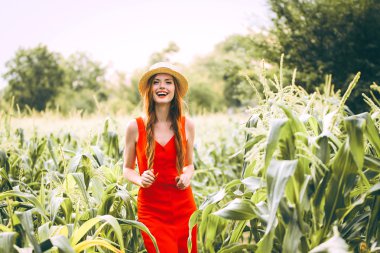   çilli kızıl saçlı kız Kırmızı elbiseli Mısır sahada yürüyüş tatlı bir gülümsemeyle onun baş yaz panama gülümsüyor