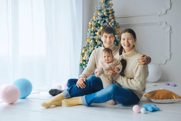 Genç gülümseyen ve çerçeve seyir Malenkov sevimli kızın kollarında, Noel ağacının altında oturan Anne