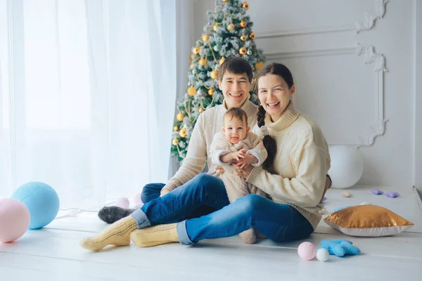 Genç gülümseyen ve çerçeve seyir Malenkov sevimli kızın kollarında, Noel ağacının altında oturan Anne