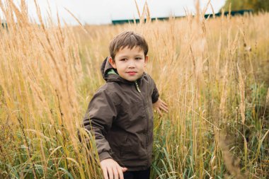 Çocuk biraz çim alanı boyunca yürüyüş. Çimen çocuk yayılır.