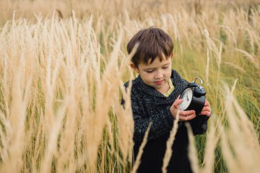 Üzgün çocuk elinde bir saatli
