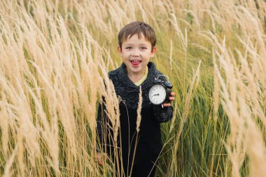 Onun elinde bir çalar saat ile mutlu çocuk