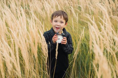 Onun elinde bir çalar saat ile mutlu çocuk