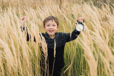 Onun elinde bir çalar saat ile mutlu çocuk