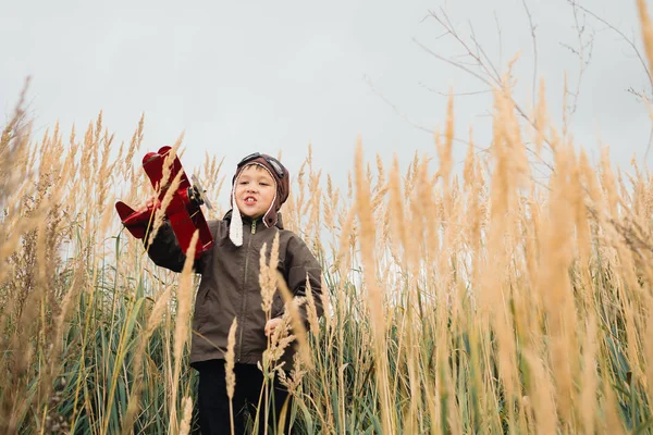 Bir çocuk kırmızı bir uçak ile oynuyor.