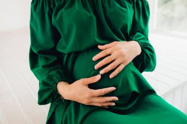 şık yeşil giysili bir hamile kadın