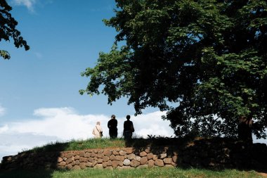 altında belgili tanımlık saye ayakta iki kadın ve bir adam