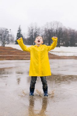 Sarı bir pelerin neşeli bir çocuk bir PO büyük bir mutlulukla atlar