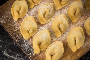 Ahşap tahta üstten görünüm üzerinde taze hazırlanmış İtalyan tortellini