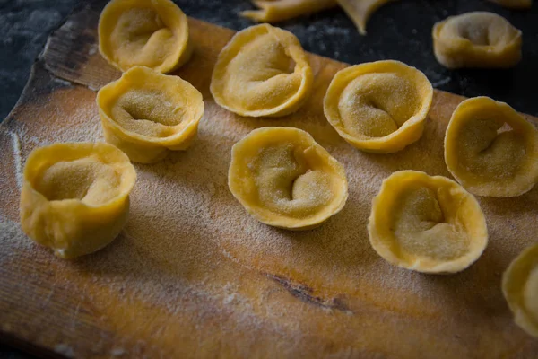 Freshly prepared Italian tortellini on wooden board — Stock Photo, Image