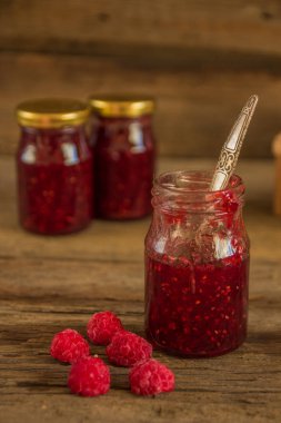 ahşap masa üzerinde bir kavanoza Ahududu reçeli