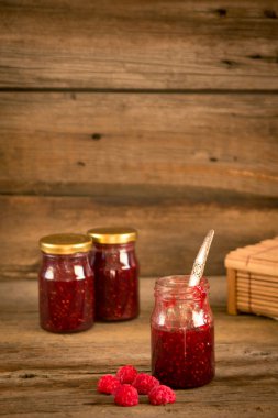 ahşap masa üzerinde bir kavanoza Ahududu reçeli