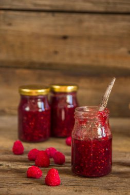 ahşap masa üzerinde bir kavanoza Ahududu reçeli