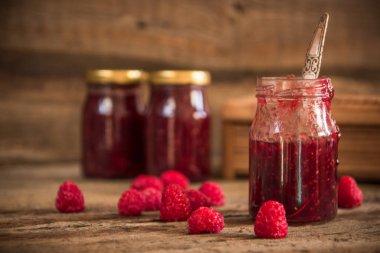 ahşap masa üzerinde bir kavanoza Ahududu reçeli
