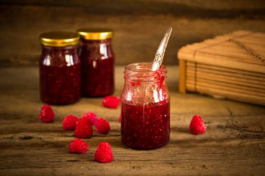 ahşap masa üzerinde bir kavanoza Ahududu reçeli