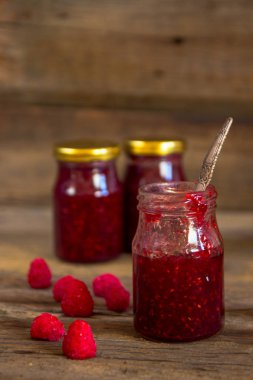 ahşap masa üzerinde bir kavanoza Ahududu reçeli