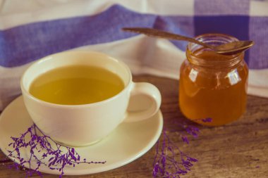 Yeşil çay bir beyaz Kupası ve kavanoz bal ile kaşık ve mavi ki