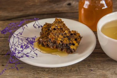 Peteğin ve bal kavanozu ve ahşap zemin üzerine yeşil çay