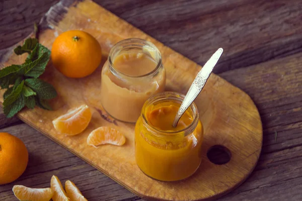Pots en verre avec nourriture naturelle pour bébé avec mandarine sur le t en bois — Photo