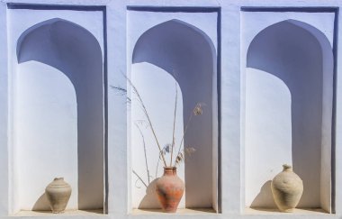 Kemerli bir niş içinde eski kil vazo ile beyaz bir duvar. Eski yaşlı pl